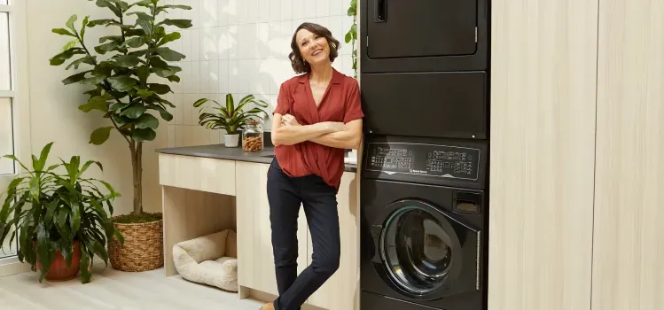 speed-queen-sf7-woman-next-to-stacked-laundry